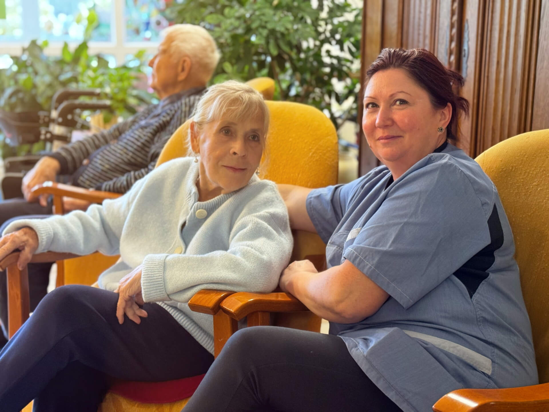 Betreuer und Bewohner sitzen in einer SItzecke