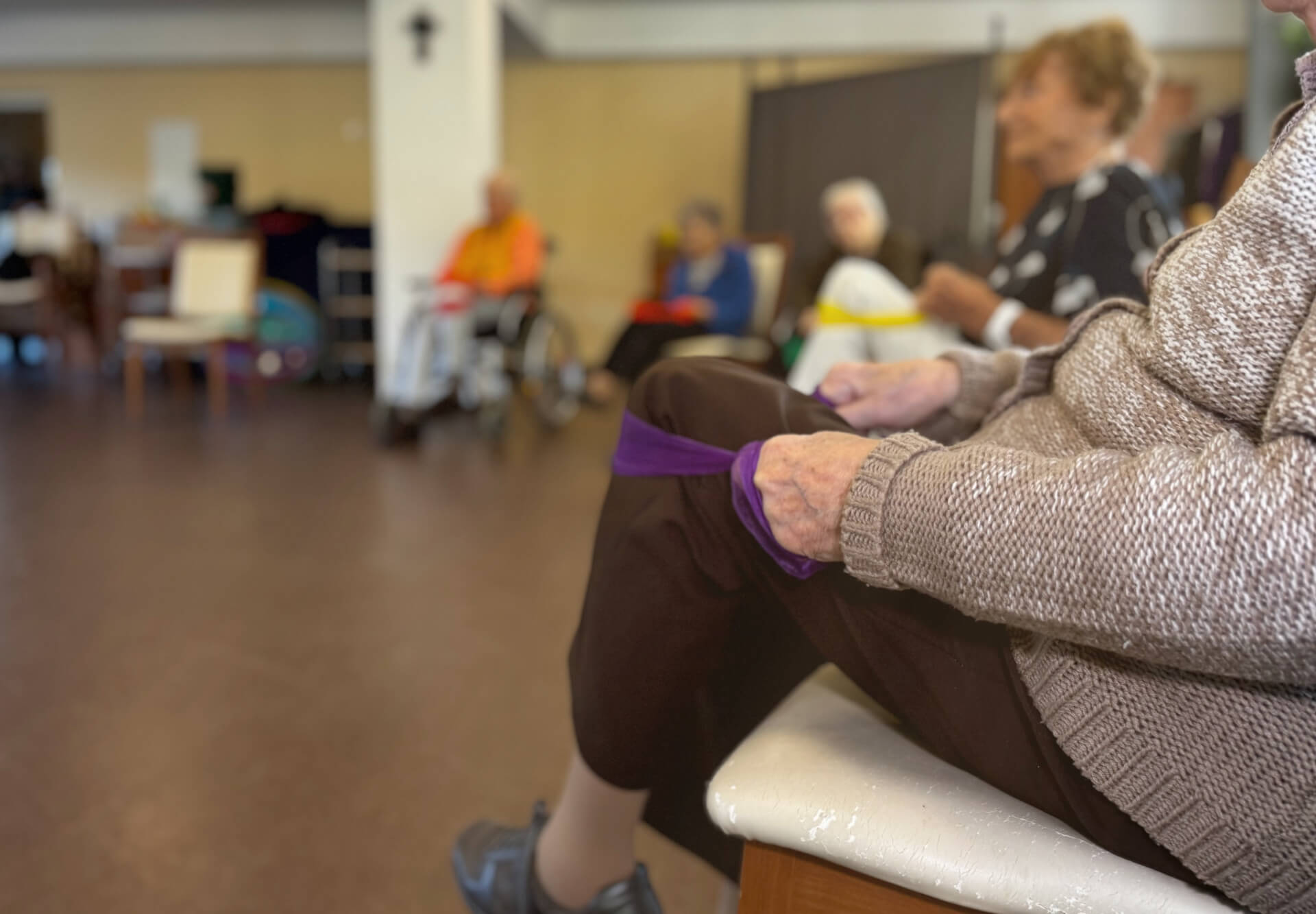 Bewohner in einem Stuhlkreis bei gymnastischen Übungen