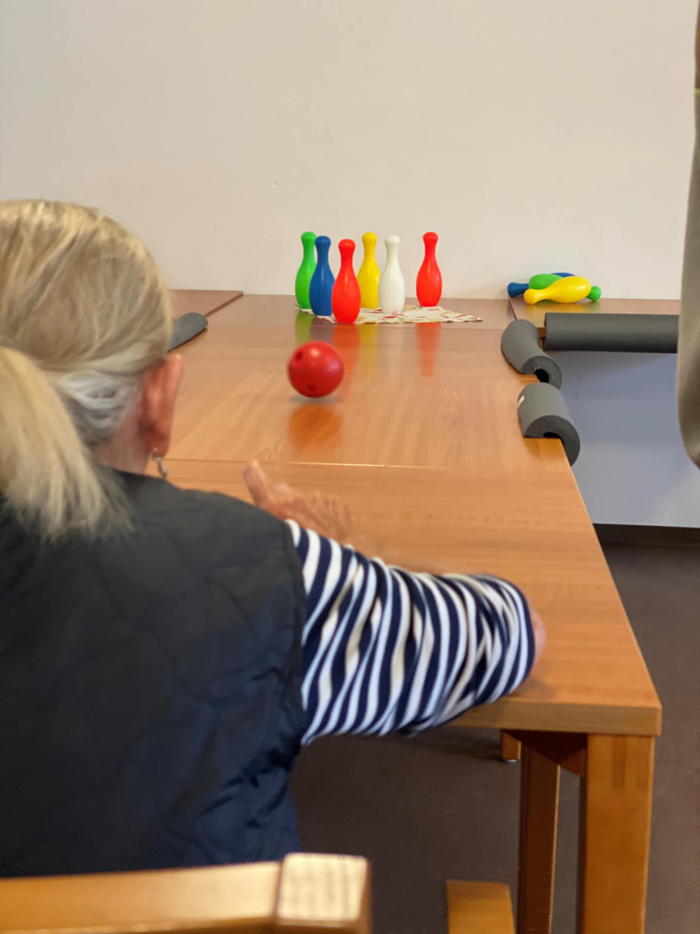Bewohnerin an einem Tisch mit Kegeln